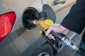 Close up of man pumping fuel in car at gas station.