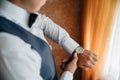 Close-up man puts on a gold watch with a leather belt, businessman is dressed in a stylish suit, a white shirt. Royalty Free Stock Photo