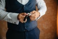 Close-up man puts on a gold watch with a leather belt, businessman is dressed in a stylish suit, a white shirt. Royalty Free Stock Photo