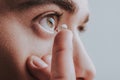 Close up on man putting contact lens into his eye