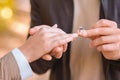CLose up of man putting ring on female finger Royalty Free Stock Photo