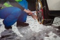 Close-up of the man putting winter chains on car wheel Royalty Free Stock Photo