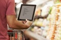 Close Up Of Man Reading Shopping List From Digital Tablet In Sup