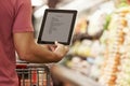 Close Up Of Man Reading Shopping List From Digital Tablet In Supermarket Royalty Free Stock Photo