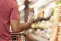 Close Up Of Man Reading Shopping List From Mobile Phone In Supermarket