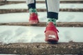 Man in red sneakers walking up the snowy stairs