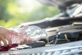 Man refill water to tank of car windshield wiper and checking up the engine before start the trip. Car maintenance or check up Royalty Free Stock Photo