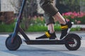 Close up of man riding black electric kick scooter at beautiful park landscape Royalty Free Stock Photo