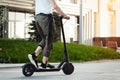 Close up of man riding black electric kick scooter at beautiful park landscape Royalty Free Stock Photo