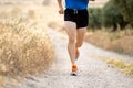 Close up of man running legs at sunset on a country road. Royalty Free Stock Photo