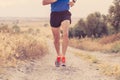 Close up of man running legs at sunset on a country road. Royalty Free Stock Photo