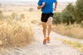 Close up of man running legs at sunset on a country road. Royalty Free Stock Photo