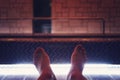 A close up of man's bare feet relaxing after swimming in indoor luxury pool. Feet selfie of relaxing near the indoor pool Royalty Free Stock Photo