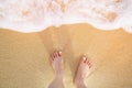 Close Up of a man`s bare feet stand at wet on the beach