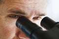 Close up of man's eyes looking through microscope