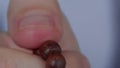 Close-up of a man`s fingers, fingering a wooden rosary