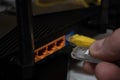 Close-up of a man's hand, fingers connecting a network cable to a router Royalty Free Stock Photo