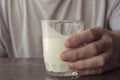 Close-up of man`s hand with half-empty glass of kefir