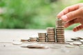 Close-up Man`s hand holding coins and stacked gold coin with colorful green bokeh background. Royalty Free Stock Photo