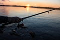 Close-up of a man`s hand holding a fishing rod on the river. Fishing at sunset on the river. Royalty Free Stock Photo