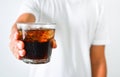 Close up man`s hand holding a glass of iced cola on white background, copy space, health care concept Royalty Free Stock Photo