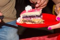 Close Up of Man`s Hand Holding a Portion of a Pink Covered Cake