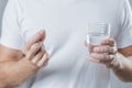 close up man s hand holding white pill glass water hand. High quality photo Royalty Free Stock Photo