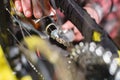 Close-up of a man`s hand, led by masters, lubricate the bicycle chain of a mountain bike with a special lubricant in the Royalty Free Stock Photo