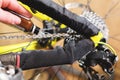 Close-up of a man`s hand, led by masters, lubricate the bicycle chain of a mountain bike with a special lubricant in the Royalty Free Stock Photo