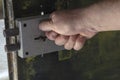 Close-up of a man`s hand locking a massive door lock on a metal door