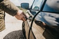 Close-up of a man`s hand opens the car door with a key Royalty Free Stock Photo