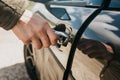 Close-up of a man`s hand opens the car door with a key Royalty Free Stock Photo