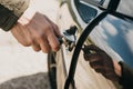 Close-up of a man`s hand opens the car door with a key Royalty Free Stock Photo