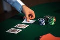Close-up of a man's hand opens the cards at a poker table with a Royalty Free Stock Photo