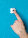 Close-up of man`s hand pressing the button of doorbell