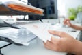 Close-up of a man`s hand pulling files from office shelves.