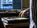 Close up man`s hand recording sound in recording music studio using new modern equipment with large monitor