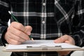 A close-up of a man`s hand signing a document with a clipboard Royalty Free Stock Photo