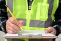 A close-up of a man`s hand signing a document with a clipboard Royalty Free Stock Photo