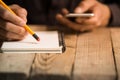 Close Up on a man`s hand writing on paper with a pencil Royalty Free Stock Photo