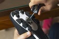 Close-up of a man`s hands assembling his cycling carbon road shoes and attaching cleats for pedals.