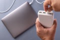 Close-up of man`s hands charge laptop with power bank by USB cable. Royalty Free Stock Photo