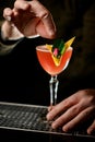 close-up of man& x27;s hands decorating glass with alcoholic cocktail by beautiful flower Royalty Free Stock Photo