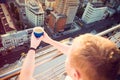 Close up man`s hands holding take away paper cup with morning hot drink - coffee or tea with inspiring view on abstract city back Royalty Free Stock Photo