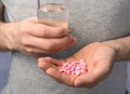 Close-up man`s hands with pills and glass of water Royalty Free Stock Photo