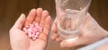 Close-up man`s hands with pills and glass of water, he is going to take some medicine