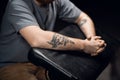 Close-up of a man`s hands with a snake tattoo on a leather tattoo table in a tattoo parlor. Royalty Free Stock Photo