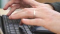 A close up of a man`s hands typing on a keyboard