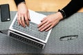 Close-up of a man`s hands typing on a laptop keyboard. Cropped image of a young man working on his laptop in a coffee shop Royalty Free Stock Photo