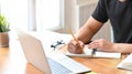 Close-up man`s hands writing on notebook paper and laptop. Royalty Free Stock Photo